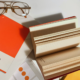 Design books, open notebook, and glasses on desk